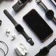 Flat lay of mobile phone accessories including chargers, earbuds, and cases on a white background.