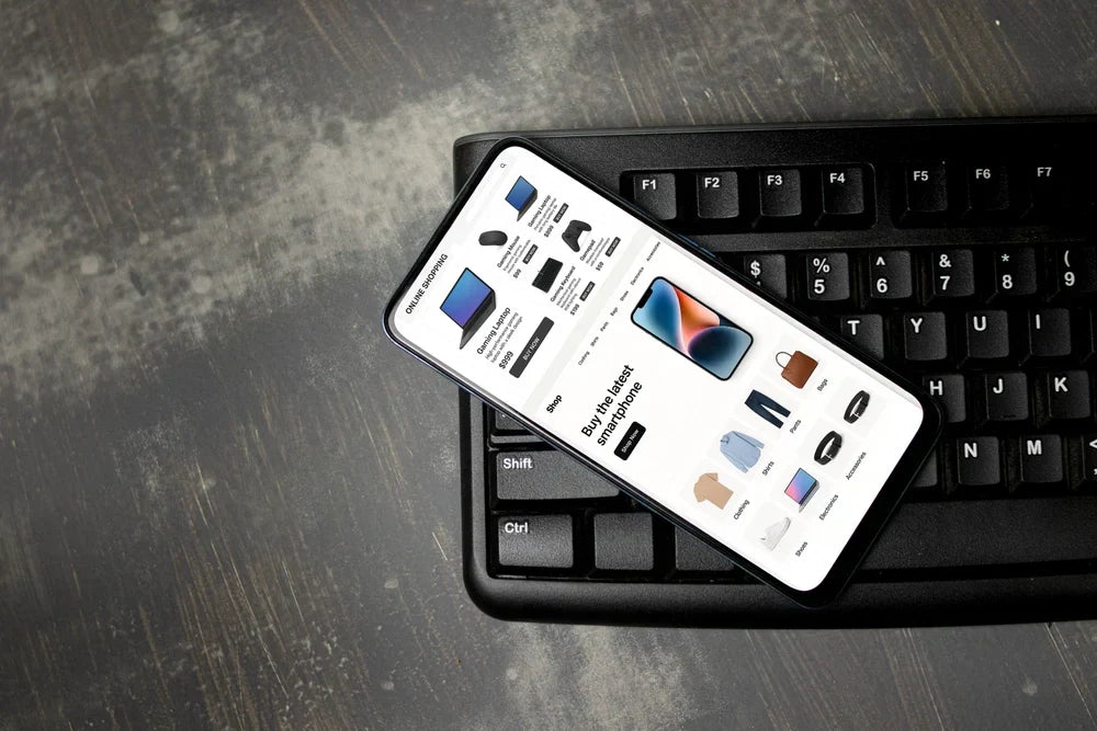 A smartphone displaying an online shopping interface for electronics and clothing.